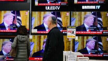 עוברי אורח במודיעין צופים בנאומו של הנשיא טראמפ. | AFP עוברי אורח במודיעין צופים בנאומו של הנשיא טראמפ. | AFP