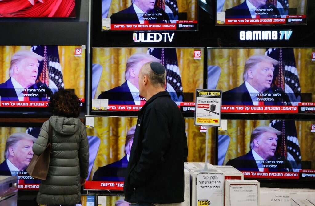 עוברי אורח במודיעין צופים בנאומו של הנשיא טראמפ. | AFP עוברי אורח במודיעין צופים בנאומו של הנשיא טראמפ. | AFP