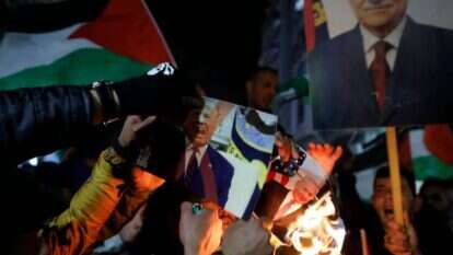 מפגינים ברמאללה מציתים את תמונת טראמפ בעקבות פרסום התוכנית. | AFP