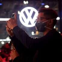 אדם עוטה מסכה בתצוגת רכבים בהודו. | EPA