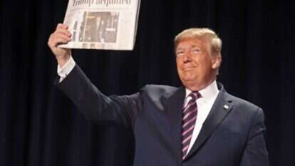 טראמפ מציג עיתון שכותרתו מכריזה על הזיכוי בסנאט. | AFP