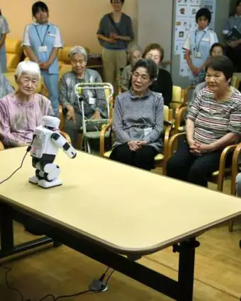 סועדים ומתזכרים את הזקן לקחת כדורים. רובוטים עם קשישים בביח אבות ביפן. | גטי אימג'ס סועדים ומתזכרים את הזקן לקחת כדורים. רובוטים עם קשישים בביח אבות ביפן. | גטי אימג'ס