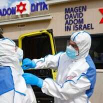 פרמדיקים בלבוש מגן, כחלק מתרגול טיפול בחולה קורונה. | AFP