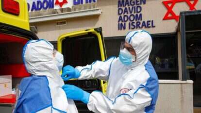 פרמדיקים בלבוש מגן, כחלק מתרגול טיפול בחולה קורונה. | AFP