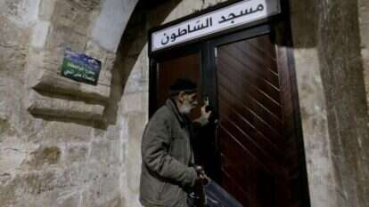 אימאם סוגר את דלת המסגד בשכם לאחר התפילה האחרונה. | EPA