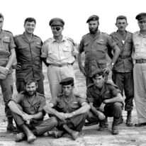 יחידה 101. עומדים, מימין לשמאל: דני מט, הרמטכ"ל משה דיין, אריק שרון ומאיר הר-ציון. למטה מימין: רפאל איתן. | אברהם ורד, עיתון במחנה יחידה 101. עומדים, מימין לשמאל: דני מט, הרמטכ"ל משה דיין, אריק שרון ומאיר הר-ציון. למטה מימין: רפאל איתן. | אברהם ורד, עיתון במחנה