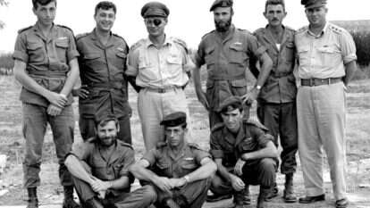 יחידה 101. עומדים, מימין לשמאל: דני מט, הרמטכ"ל משה דיין, אריק שרון ומאיר הר-ציון. למטה מימין: רפאל איתן. | אברהם ורד, עיתון במחנה