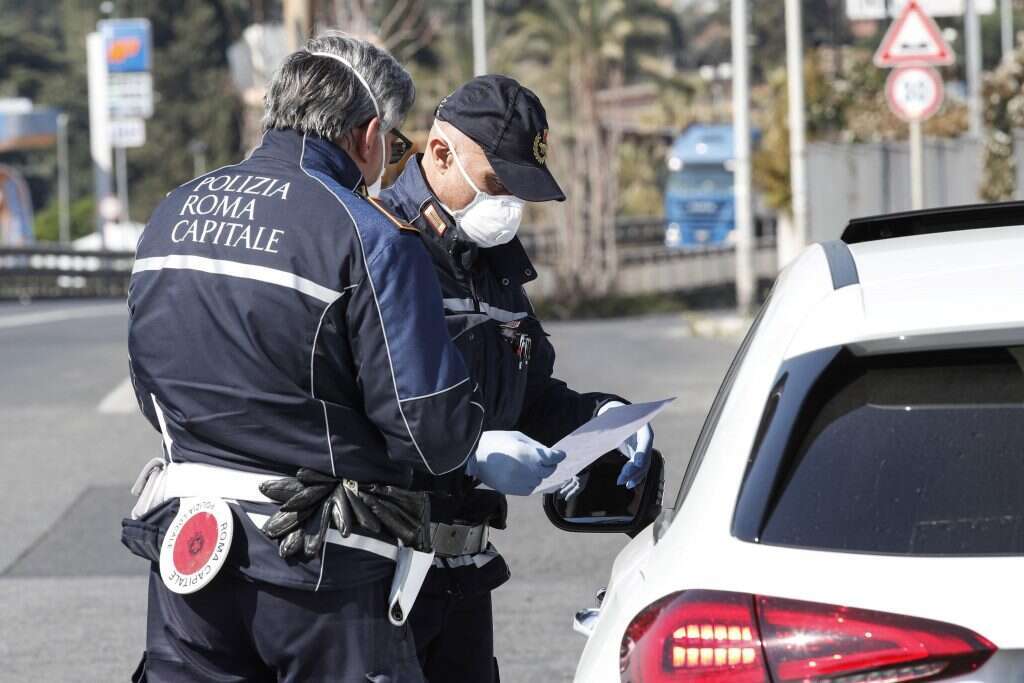 בכל רגע יש גזרות חדשות. שוטרים בודקים היתרי מעבר ברומא. | AFP בכל רגע יש גזרות חדשות. שוטרים בודקים היתרי מעבר ברומא. | AFP