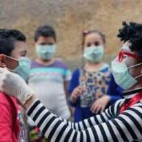 הליצן המצרי, אחמד נאסר מחלק מסיכות לילדים בקהיר. | EPA