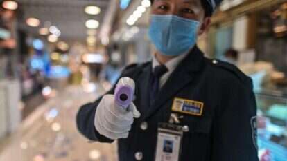 מדידת חום בכניסה לאזור מסעדות בשנגחאי. | AFP