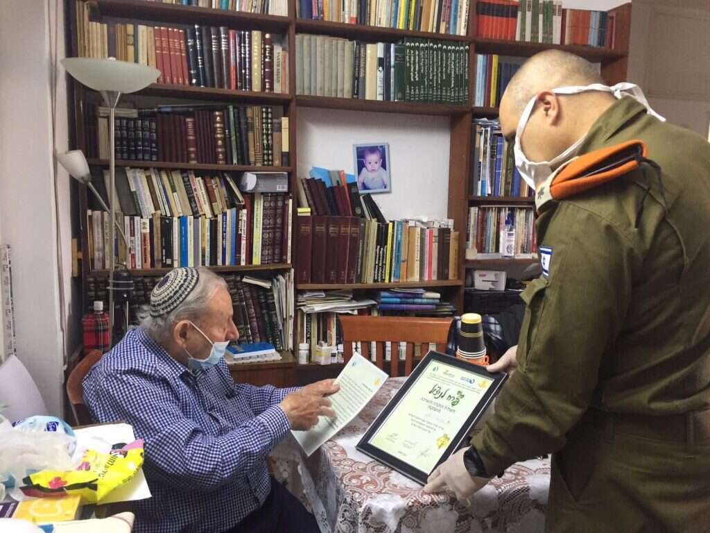 מפקד מחוז ירושלים והמרכז, אל״ם איתי לוי, עם ניצול השואה אברהם גליק. | דו"צ