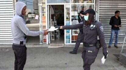 חלוקת דפי הסברה בעניין הקורונה בדרום תל־אביב. למצולמים אין קשר לכתבה. | גדעון מרקוביץ'