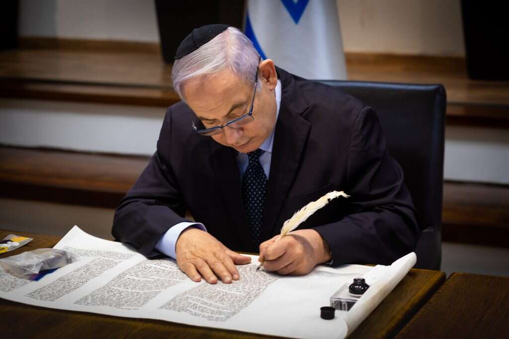 נתניהו כותב אות בספר תורה לעילוי נשמת סמ"ר עמית בן יגאל ז"ל. | אריק סולטן
