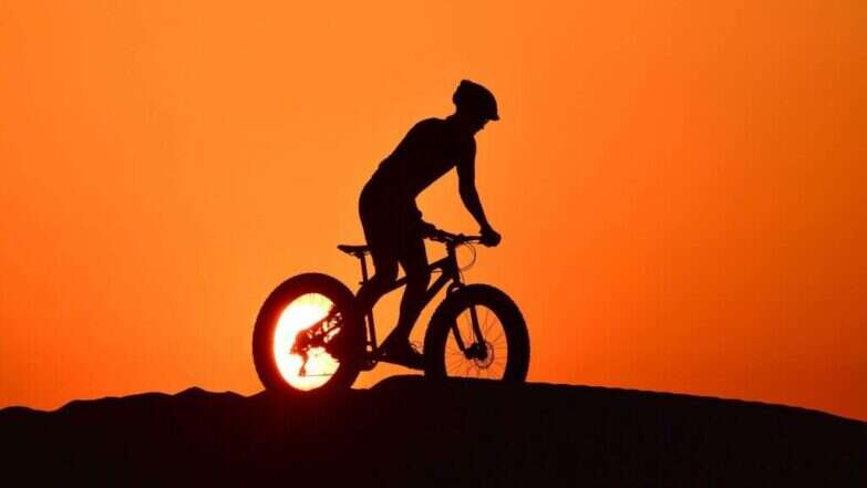 רוכב אופניים במדבר אל-קודרה בדובאי. | AFP רוכב אופניים במדבר אל-קודרה בדובאי. | AFP