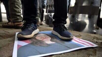 מפגין עומד מעל תמונה של שגריר, ארה"ב בלבנון, דורותי שי, במהלך הפגנה מול משרד החוץ בביירות/ mhkuo: EPA