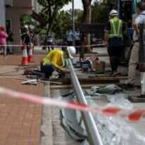 פועל מתקין מוט דגל מול המלון. | EPA