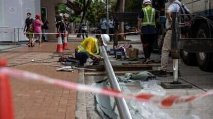 פועל מתקין מוט דגל מול המלון. | EPA