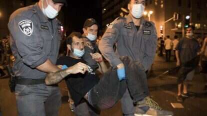 שוטרים מפנים מפגין בהפגנה מול בלפור. | EPA