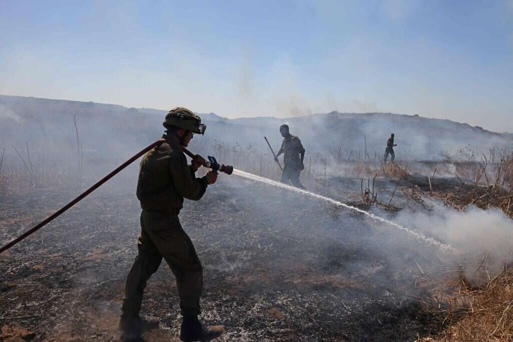 חיילי צה"ל מכבים שריפה בקיבוץ ניר־עם, השבוע. | AFP
