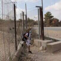 ילד פלסטיני חוצה את הגדר בדרך לים בישראל. | EPA
