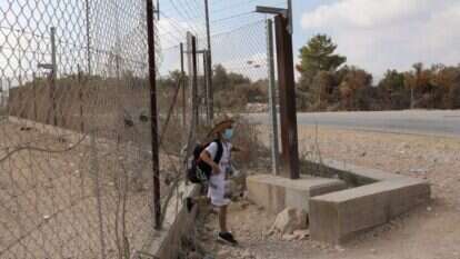 ילד פלסטיני חוצה את הגדר בדרך לים בישראל. | EPA