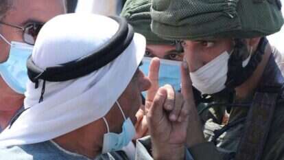 פלסטיני מתווכח עם חיילי צה"ל. אילוסטרציה. | AFP