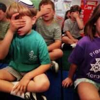 עיוניו של הרב שג"ר נופלים בין הכיסאות: הם אינם משתייכים במובהק למרחב הלמדני הקלאסי ואף לא למרחב המחקרי. ילדי כיתה א' בתפילת "שמע ישראל", לוס אנג'לס ארה"ב. | גטי אימג'ס