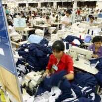 הרעב חוסל למעשה בווייטנאם, ומיליוני אנשים יכולים להרשות לעצמם תזונה איכותית יותר. עובדיות וייטנאמיות בקו ייצור של בגדי ספורט עבור "נייק", 2003. | AFP