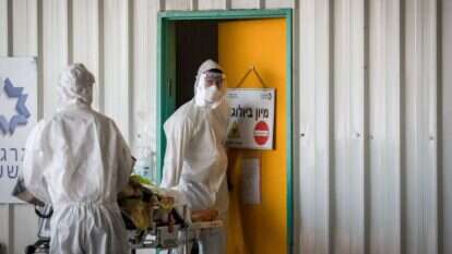 להחליט בתוך דקות במי לטפל. סניטרים מובילים חולה לחדר מיון קורונה בבית החולים שערי צדק. | נתי שוחט, פלאש 90