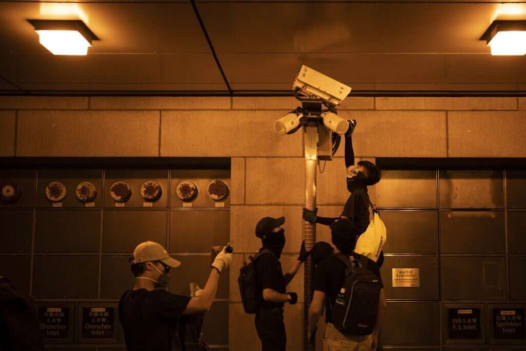 מפגינים בהונג־קונג מנסים לפגוע במצלמות המוצבות במרחבים הציבוריים. | AP