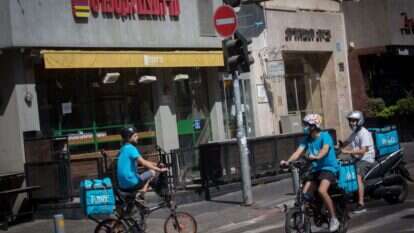 מגפת הקורונה הזכירה לנו עד כמה לא היינו יכולים להתקיים כחברה ללא אותם עובדים חיוניים מדוברים כמו שליחי המזון המהיר. שליחי וולט בתל־אביב, 2020. | מרים אלסטר, פלאש 90