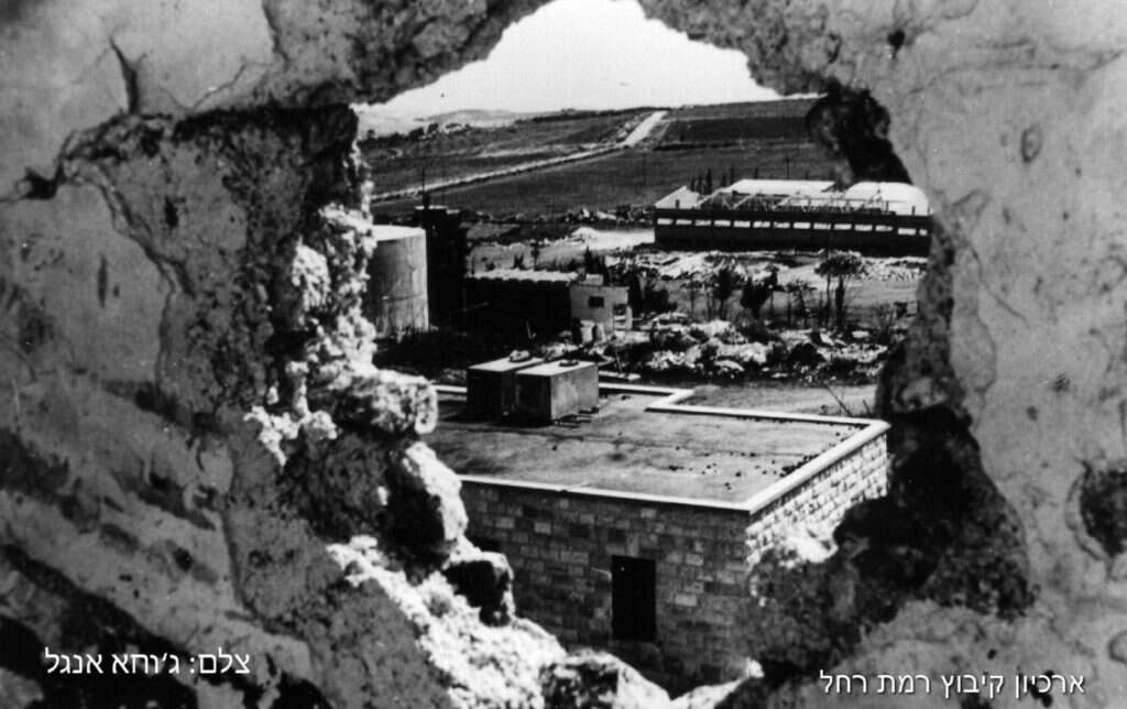 פגזים נפלו בתחומי המשק ללא אבדות בנפש. הקיבוץ מבעד לחור שיצר פגז. | יוסף אבי יאיר אנגל (ג'וחא)