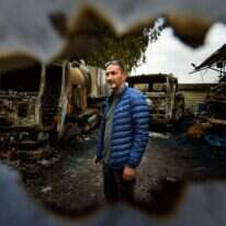 רפי דעדוש ומשאיותיו השרופות סמוך לצומת אגמון החולה, השבוע. | אייל מרגולין, ג'יני