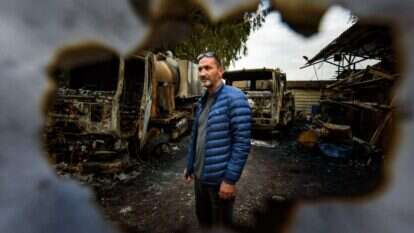 רפי דעדוש ומשאיותיו השרופות סמוך לצומת אגמון החולה, השבוע. | אייל מרגולין, ג'יני