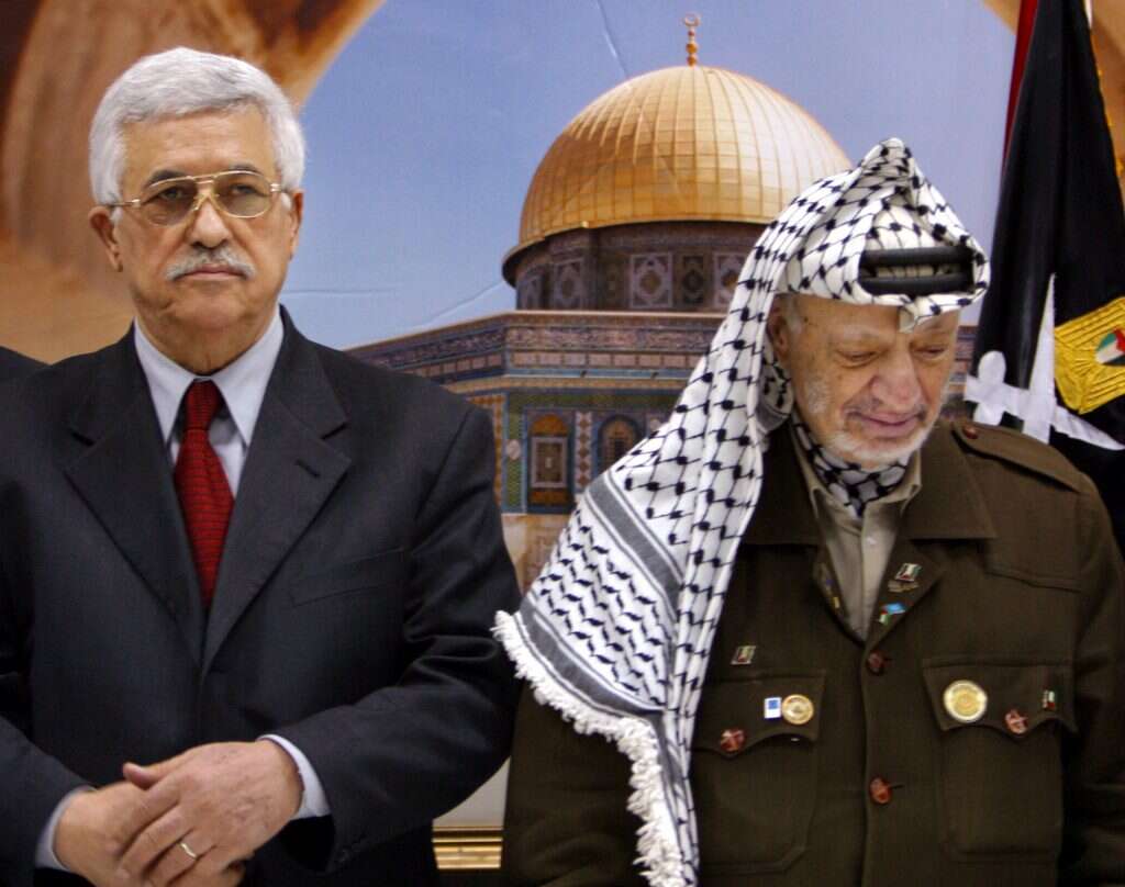 ערפאת (מימין) משפיל את עיניו לאחר השבעת אבו־מאזן לראש ממשלת הרשות הפלסטינית, 2003. | AP