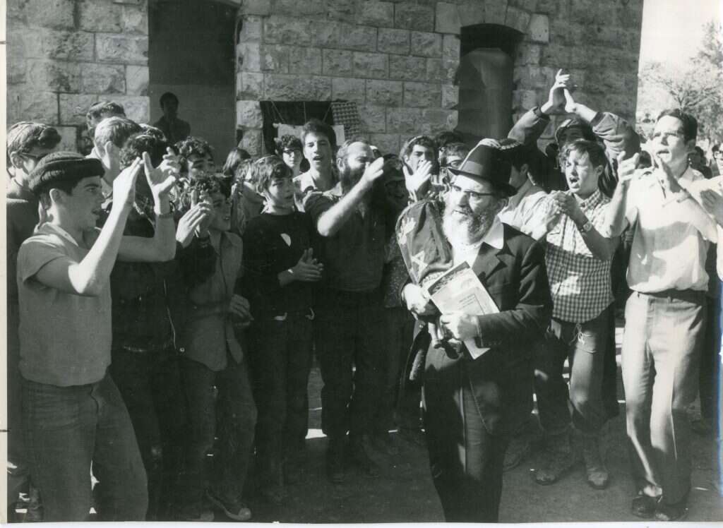 ה"עוצו עצה" בהפגנות גוש אמונים אינו אלא תולדה מוסיקלית וכוריאוגרפית של ההווי שהנהיג בישיבה בסעודות ליל שבת. | שעיה סגל