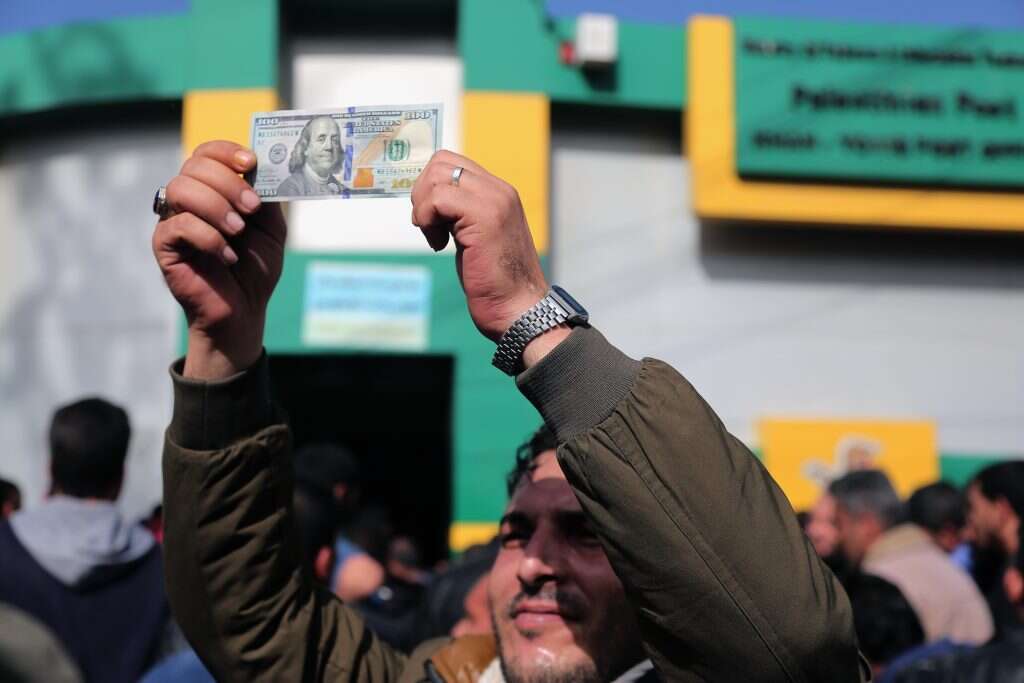 להתייחס לנושא הכסף כמשני וטקטי, זו טעות". תושב עזה מניף שטר שהתקבל מקטאר. | גטי איצג'ס להתייחס לנושא הכסף כמשני וטקטי, זו טעות". תושב עזה מניף שטר שהתקבל מקטאר. | גטי איצג'ס