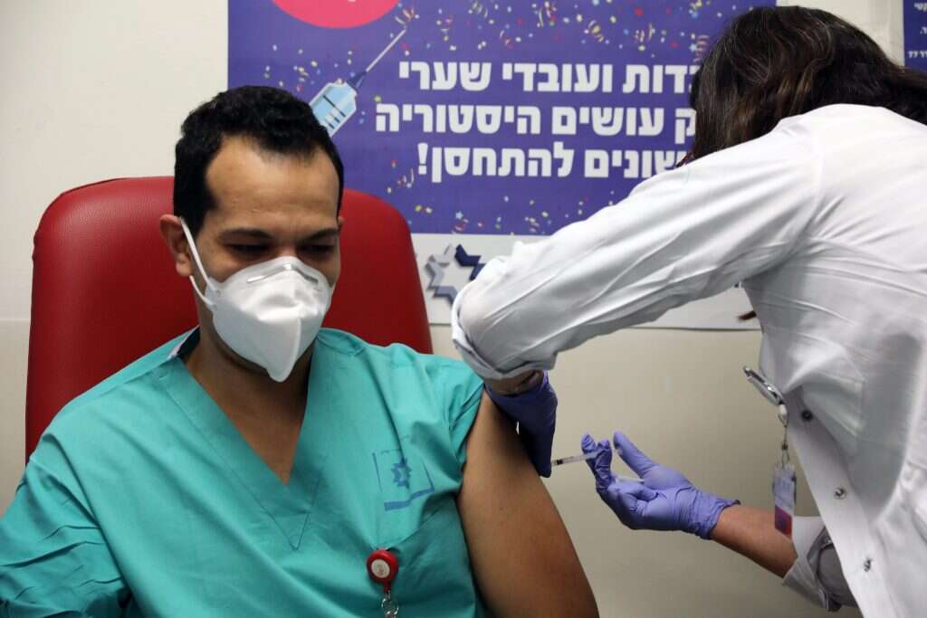 עובד בריאות בבית חולים שערי צדק מקבל חיסון נגד קורונה. | AFP