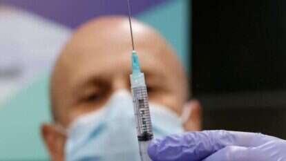 עובד בריאות מחזיק את החיסון החדש של פייזר בבית החולים שיבא. | AFP