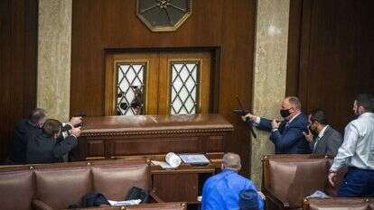 מאבטחים באקדחים שלופים מול דלתות בית הנבחרים החסומות. | ביל אולירי, הוושינגטון פוסט