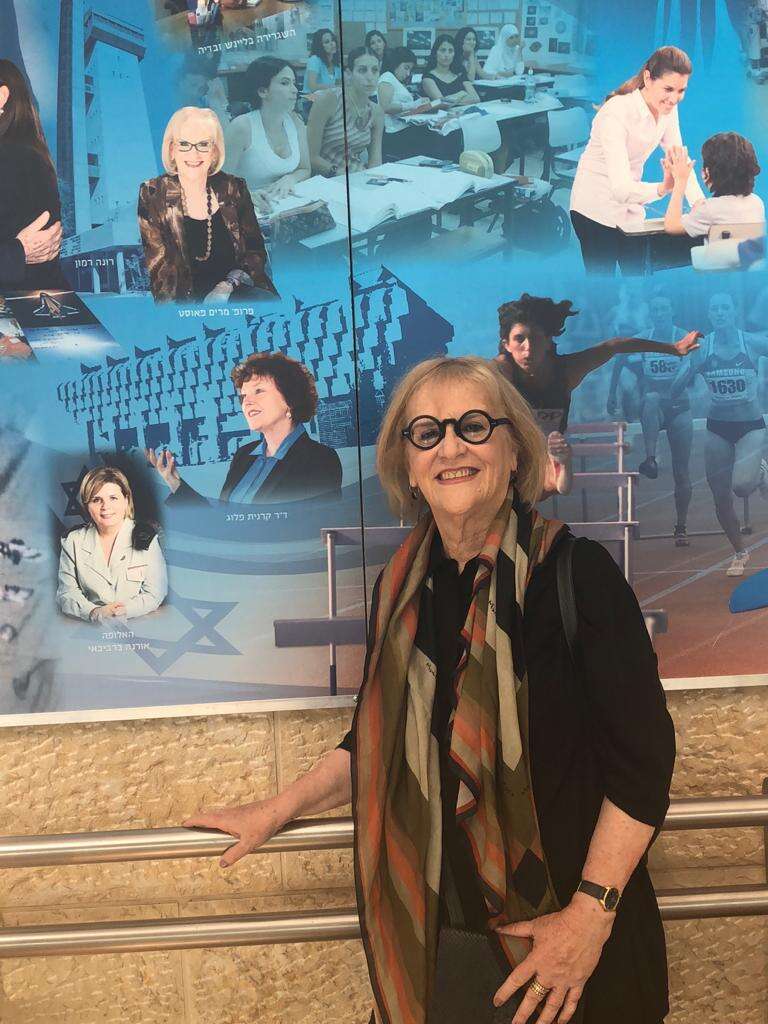 פאוסט ליד תמונתה בתערוכה "נשים פורצות דרך בישראל" בנתב"ג. | באדיבות המצולמת