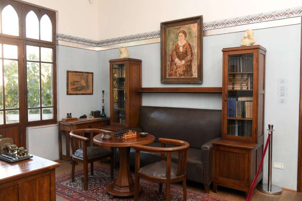 חלק מתוך חדר העבודה של ביאליק. ברקע התמונה של מניה בציור של חיים גליקסברג, מימין ומשמאל פסלים של יהודית ומתיתיהו מאת בוריס שץ, משמאל תמונה של טולסטוי בחדר עבודתו מאת פסטרנק. | יוסי זליגר חלק מתוך חדר העבודה של ביאליק. ברקע התמונה של מניה בציור של חיים גליקסברג, מימין ומשמאל פסלים של יהודית ומתיתיהו מאת בוריס שץ, משמאל תמונה של טולסטוי בחדר עבודתו מאת פסטרנק. | יוסי זליגר