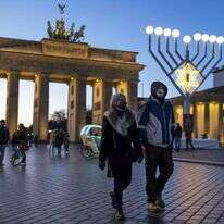 מטיילים ליד שער ברנדנבורג בחג החנוכה, ברלין, 19 בדצמבר 2020. | AFP