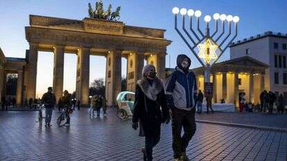 מטיילים ליד שער ברנדנבורג בחג החנוכה, ברלין, 19 בדצמבר 2020. | AFP