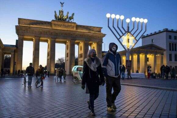 מטיילים ליד שער ברנדנבורג בחג החנוכה, ברלין, 19 בדצמבר 2020. | AFP מטיילים ליד שער ברנדנבורג בחג החנוכה, ברלין, 19 בדצמבר 2020. | AFP