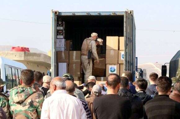 חיילים מפיצים סיוע הומניטרי לפליטים סורים במרכז הדיור באל-חרג'לה בכפר דמשק. | EPA