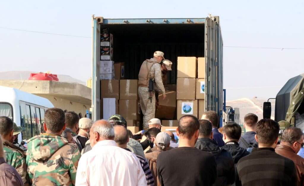 חיילים מפיצים סיוע הומניטרי לפליטים סורים במרכז הדיור באל-חרג'לה בכפר דמשק. | EPA