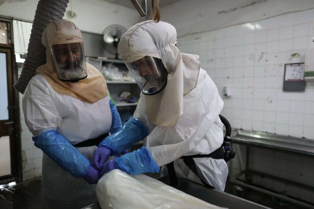 אף אחד לא יוצא למרפסות למחוא כפיים. עובדי חברה קדישא בחולון, החודש. | EPA