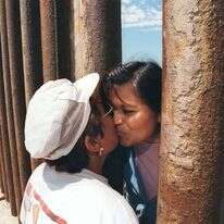 העלילה והדמויות נועדו ליצור הזדהות עם חוויית ההגירה. אם ובתה משני צידי גדר ההפרדה בין מקסיקו לארה"ב, 1997. | AFP