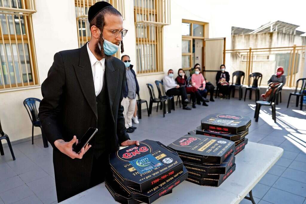 חלוקת מגשי הפיצה למתחסנים בבני-ברק. השבוע. | AFP